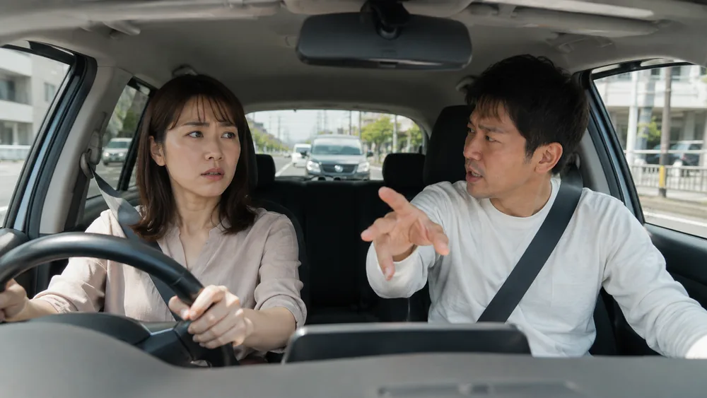 助手席の同乗者から助言を受けながら運転する方のイメージ